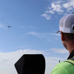 A UAV employee utilizing a drone flying in the sky